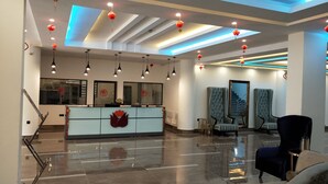 A modern hotel lobby with a reception desk, seating area, and a staircase. - Soluxe Hotel Cotonu (Cotonou)