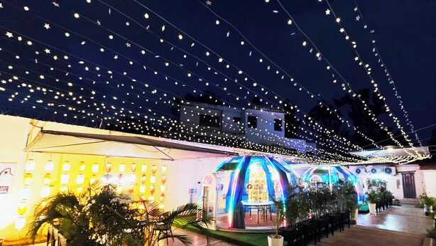 A courtyard with string lights, a covered seating area, and potted plants. - Soluxe Hotel Cotonu (Cotonou)