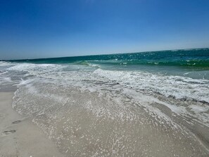 A beach with waves approaching the shore.