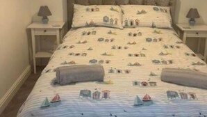 Une chambre à coucher avec un lit, deux tables de chevet et une tête de lit.