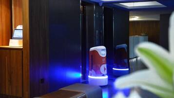 A modern spa area with a massage chair and a digital interface.