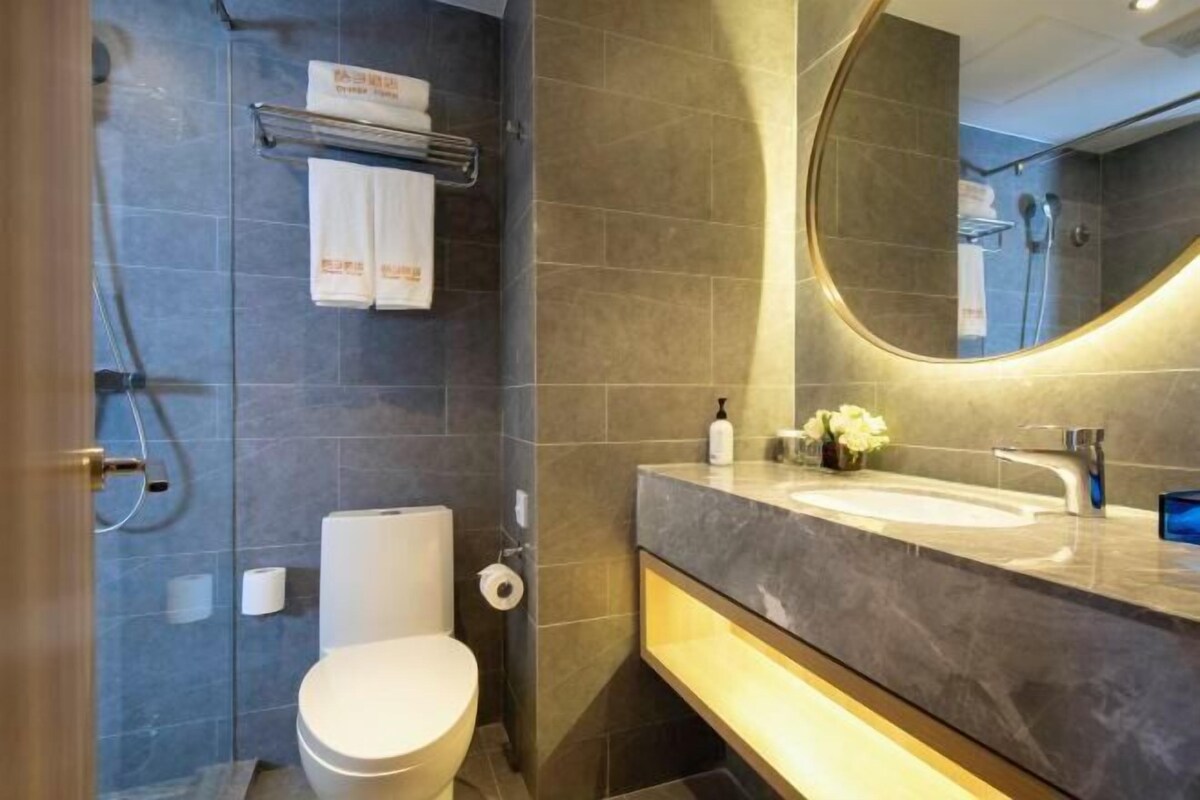 Une salle de bain moderne équipée de toilettes, d’un lavabo et d’une zone douche.