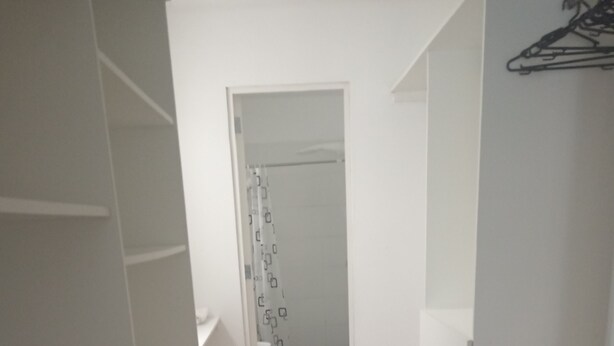 A narrow hallway with wooden flooring, white walls, and a door leading to a bathroom with a shower curtain. - Jesús maría Apartment 3 complete Spacious, centrally located. (Jesús María)