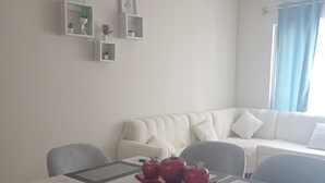 A dining area with a table set for four, a white sofa, and wall-mounted shelves with decorative items. - Jesús maría Apartment 3 complete Spacious, centrally located. (Jesús María)