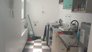A narrow kitchen with checkered flooring, a window, and basic amenities. - Jesús maría Apartment 3 complete Spacious, centrally located. (Jesús María)