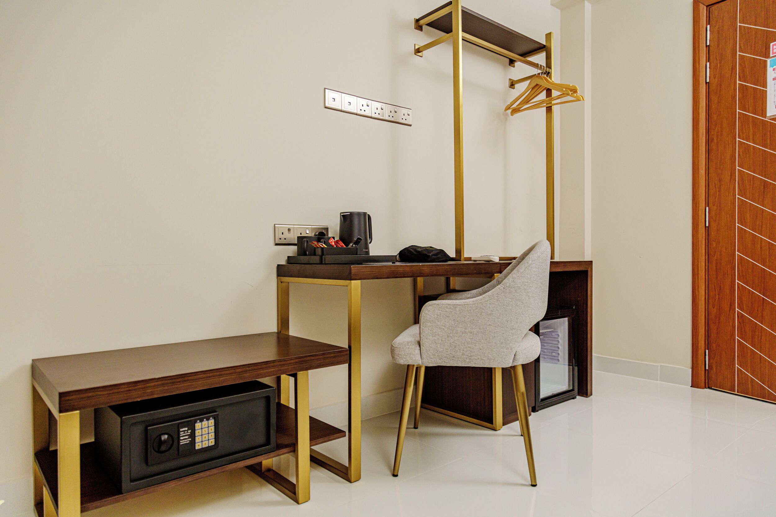 A compact workspace with a desk, chair, and a safe.