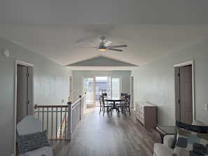Uma sala de estar ampla com área de jantar, escada e varanda.