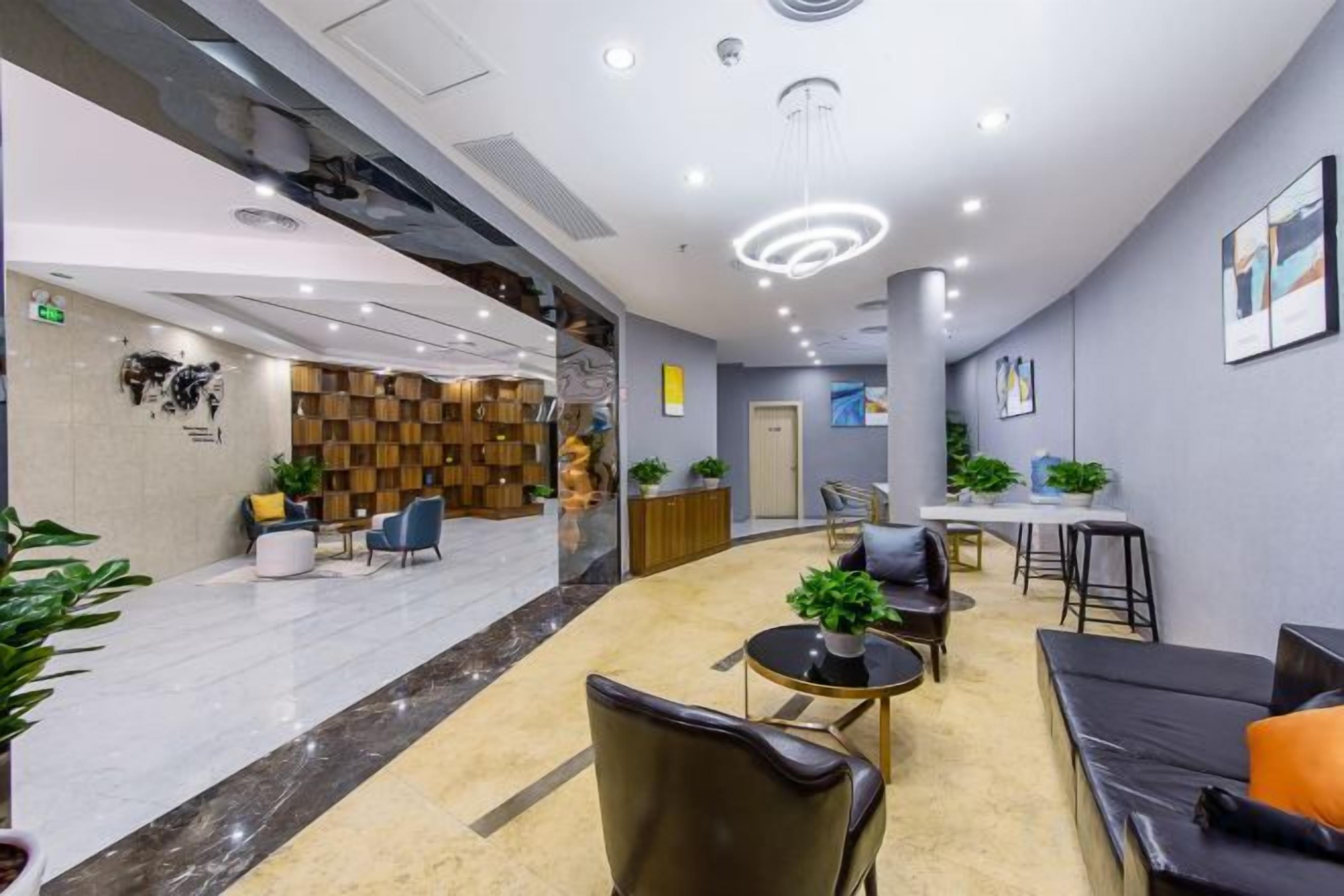 A modern lobby with a reception desk, seating area, and a staircase.