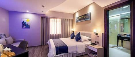 A hotel room with a bed, bedside table, and a desk with a chair.