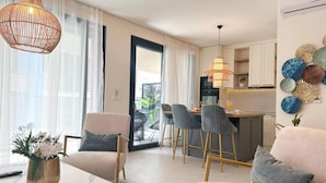 A modern living room with a dining area, kitchen, and balcony. - Leonarda Waterfront Residences (Zadar)