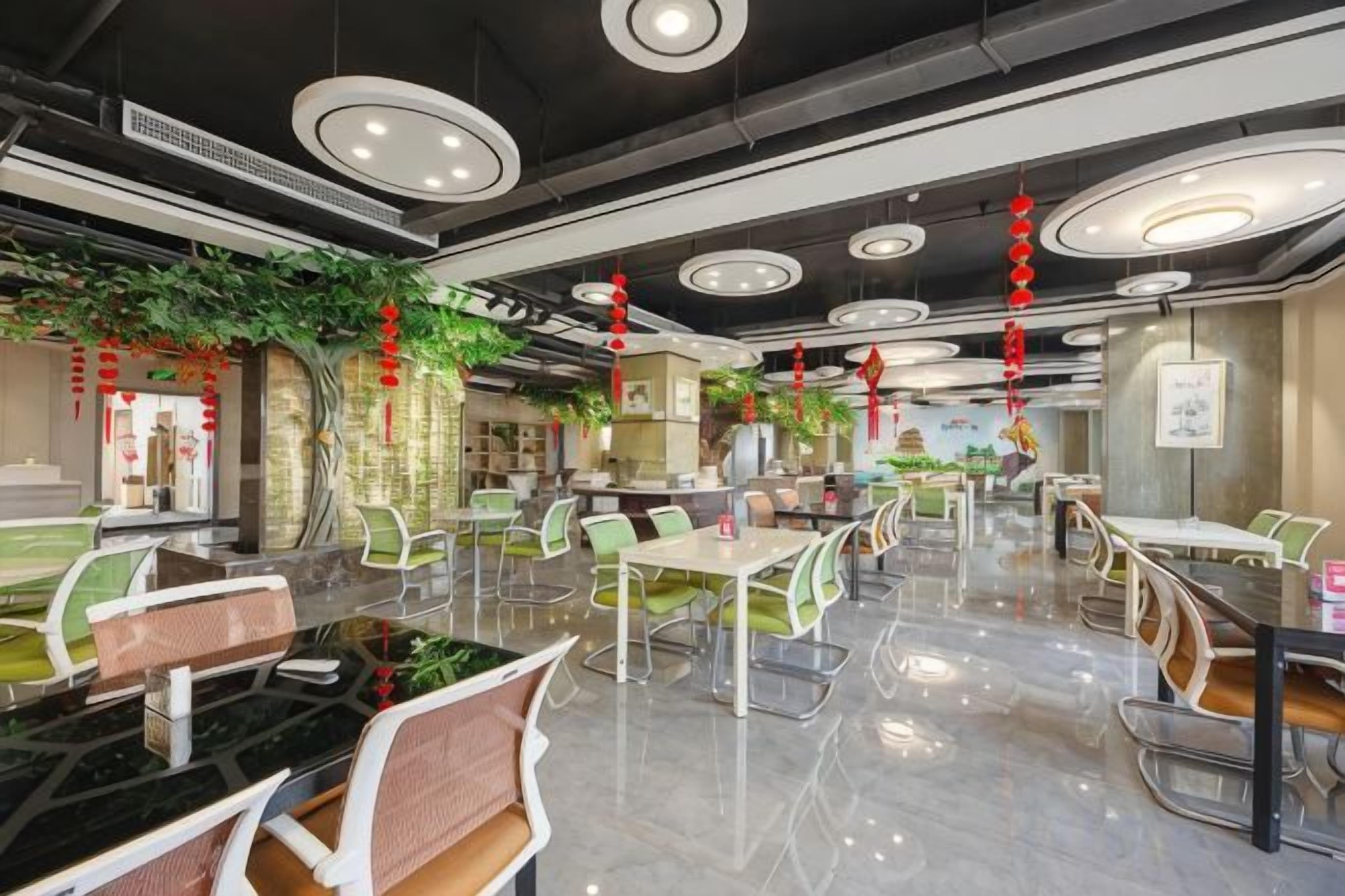 A modern dining area with round tables, green chairs, and a polished floor.