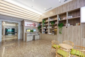 A reception area with a reception desk, seating area, and bookshelves. - Yuncheng Juhetai Hotel (Yanhu South Wind Square) (Yuncheng)