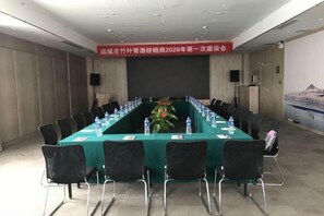 A conference room with a long table, chairs, water bottles, and a floral arrangement. - Yuncheng Juhetai Hotel (Yanhu South Wind Square) (Yuncheng)