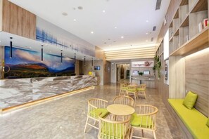 A hotel lobby with a reception desk, seating area, and a large TV screen. - Yuncheng Juhetai Hotel (Yanhu South Wind Square) (Yuncheng)