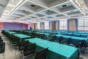A conference room with rows of tables and chairs, large windows, and a high ceiling with lighting fixtures. - Yuncheng Juhetai Hotel (Yanhu South Wind Square) (Yuncheng)