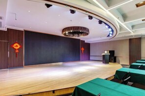 A conference room with a stage, seating, and a podium. - Yuncheng Juhetai Hotel (Yanhu South Wind Square) (Yuncheng)