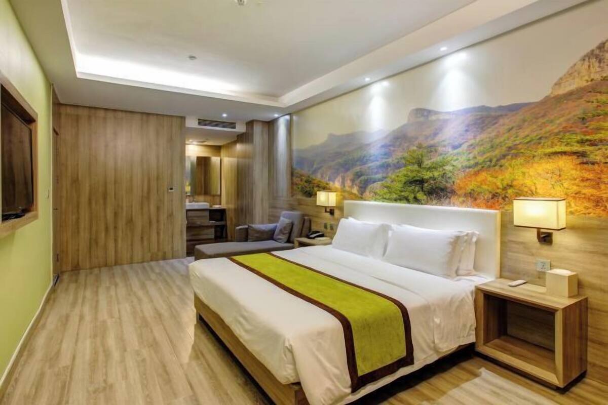 Ein Hotelzimmer mit einem großen Bett, einem Schreibtisch und einem Stuhl.