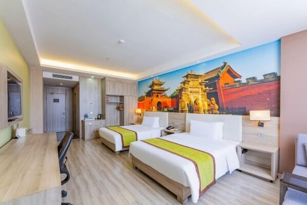 A hotel room with two beds, a desk, a TV, and a mural of a traditional building. - Yuncheng Juhetai Hotel (Yanhu South Wind Square) (Yuncheng)