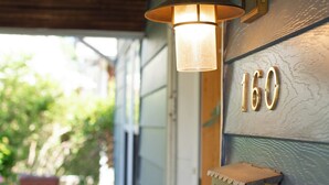 A house number 160, a porch with a table and chairs, and a wall-mounted light fixture.
