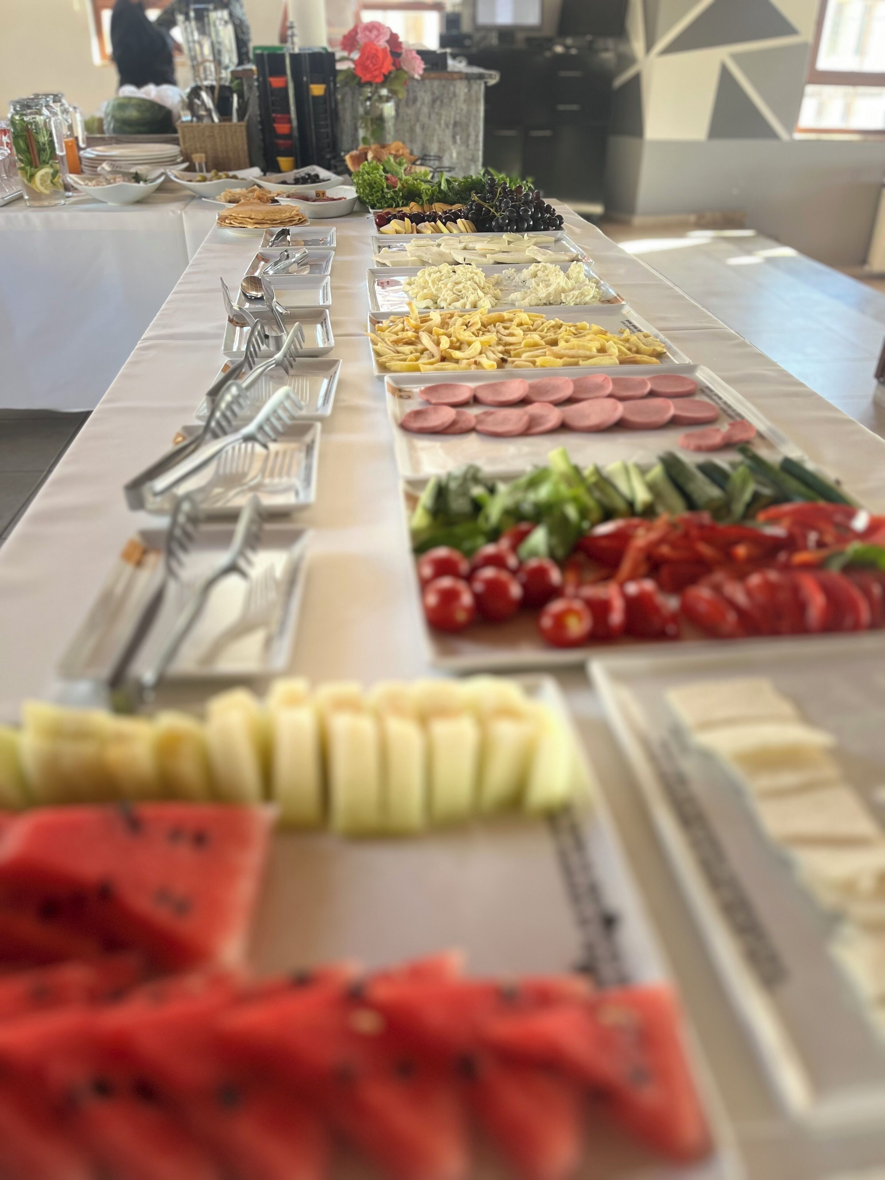 A buffet table with various food items and utensils.