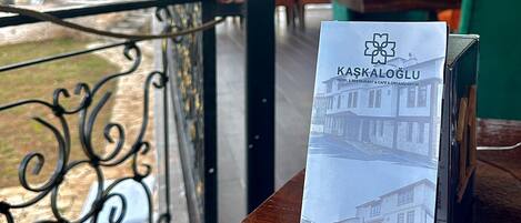 Un folleto sobre una mesa, con vista a un balcón y zona de estar al aire libre.