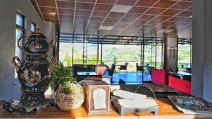 A table with a decorative teapot, a woven basket, and a wooden box with a white label. - Kaşkaloğlu Hotel (Arapgir)