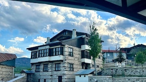 A multi-story stone building with a flat roof and multiple windows. - Kaşkaloğlu Hotel (Arapgir)