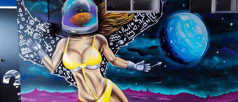 Un mural con una obra de arte alusiva al espacio en una pared.
