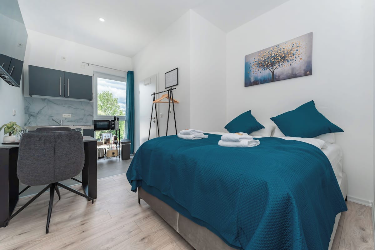 A modern bedroom with a bed, a desk, and a chair.