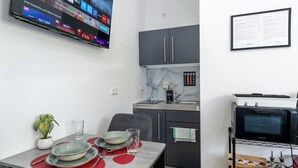 A modern kitchen with grey cabinets, a marble backsplash, and a built-in microwave. - Lit Living-Luxury-Box Spring - Parking (Altenstadt)