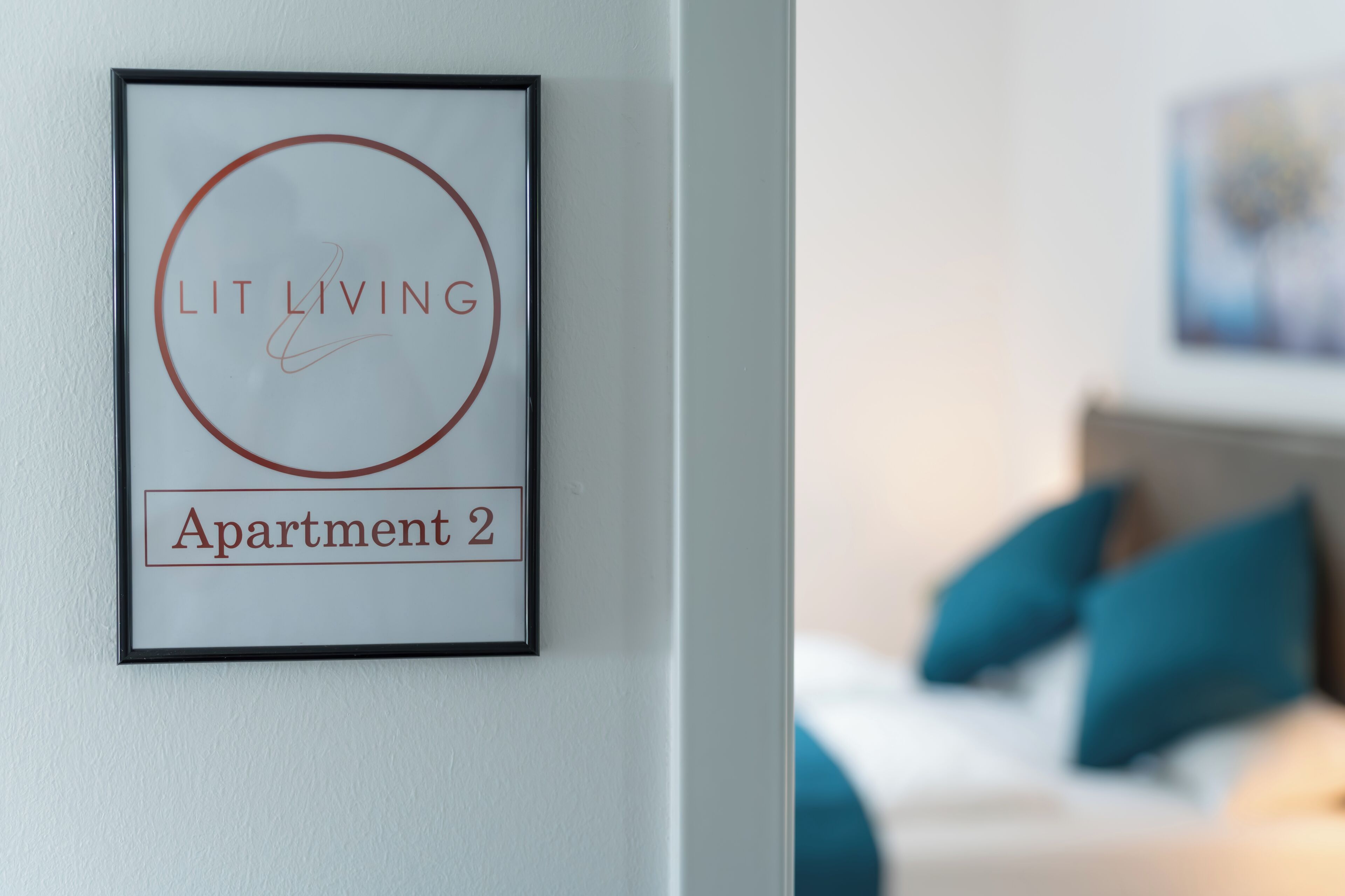 A framed sign with 'Lit Living' and 'Apartment 2' indicating the apartment's name.