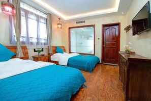 A hotel room with two beds, a wooden floor, a TV, and a large mirror. - Yina Inn (Lijiang Ancient City Dashuiche) (Lijiang)