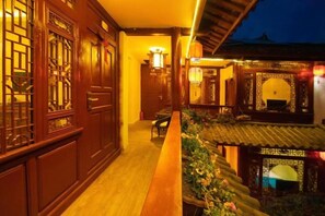 A traditional wooden corridor with a bench, a lantern, and a tiled roof structure. - Yina Inn (Lijiang Ancient City Dashuiche) (Lijiang)