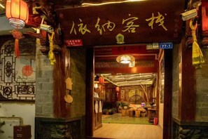 A traditional Chinese interior with a wooden door, lanterns, and a sign with Chinese characters. - Yina Inn (Lijiang Ancient City Dashuiche) (Lijiang)