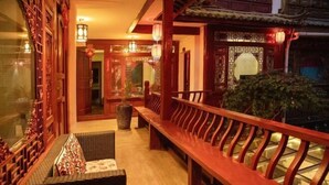 A traditional Chinese courtyard with wooden benches and lanterns.