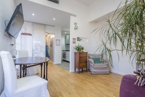 Relax in this stylish living area with a dining table, flat-screen TV, and comfortable seating.