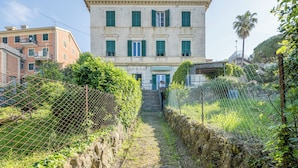 A building with a stone facade, green shutters, and a staircase leading to a door. - Central Cozy Nest With Parking Bogliasco (Bogliasco)
