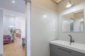 A modern bathroom with a white sink, a mirror, and a light fixture. - Central Cozy Nest With Parking Bogliasco (Bogliasco)