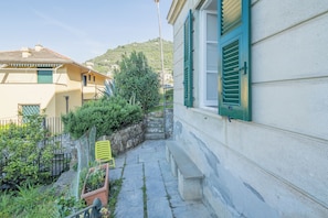 Stroll along the serene garden path to this charming building, surrounded by lush greenery and a picturesque hillside view.