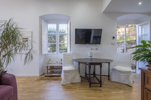 Relax in this open-plan living area with a large flat-screen TV and comfortable seating for two.