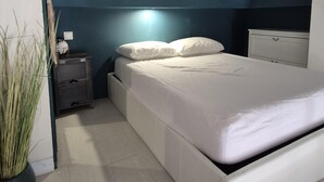 Ein modernes Schlafzimmer mit Bett, Nachttischen und einem Beistelltisch.