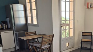 Eine kleine Küche mit Essbereich, einem Kühlschrank und einem Fenster mit Blick.
