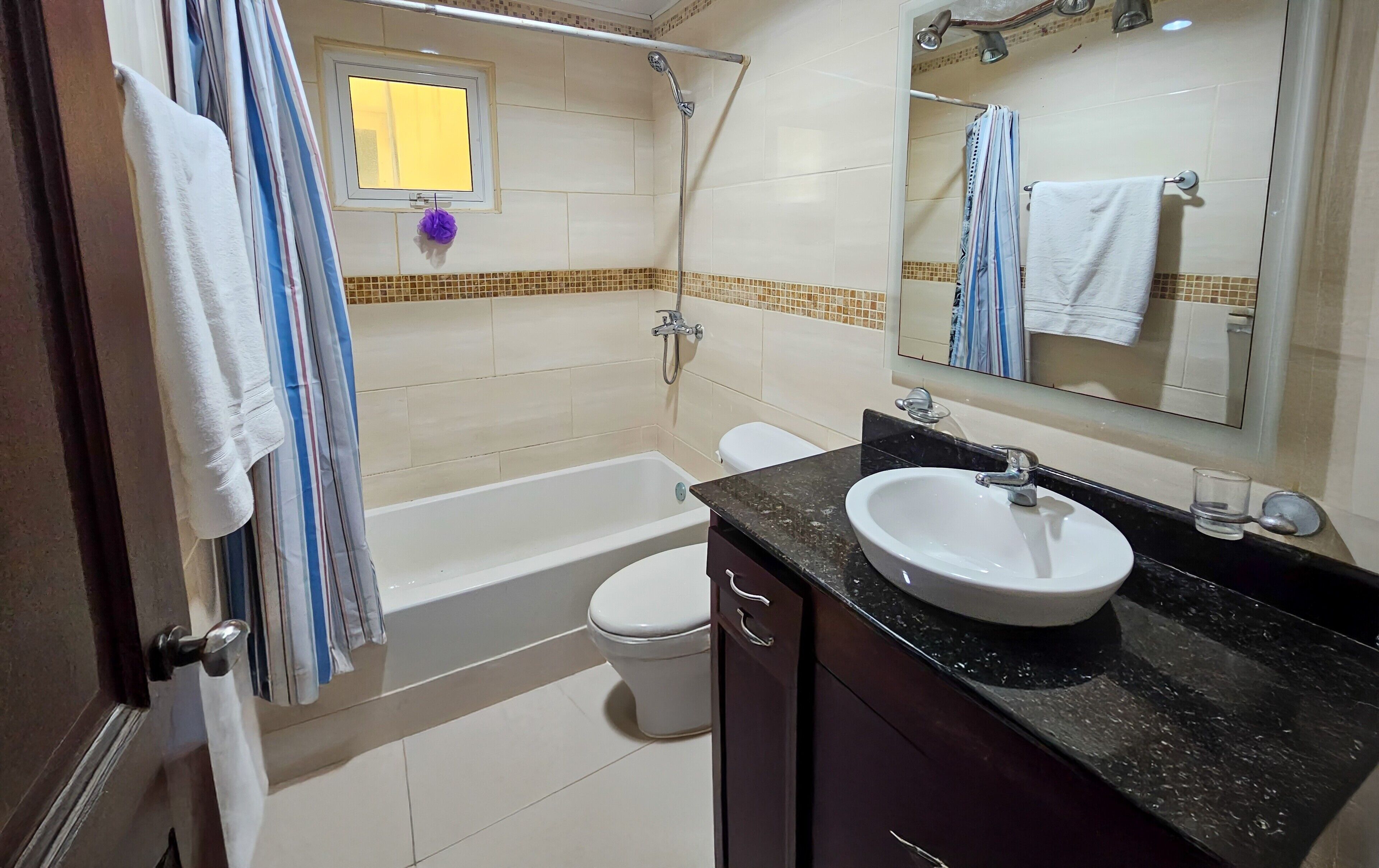 A bathroom with a bathtub, toilet, and sink.