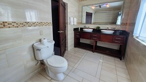 Un baño con inodoro, lavamanos y espejo.