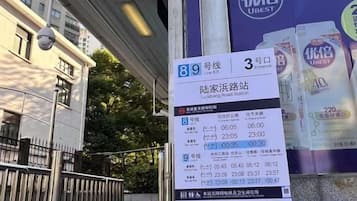 A bus stop sign with bus route information and a U-BEST advertisement.