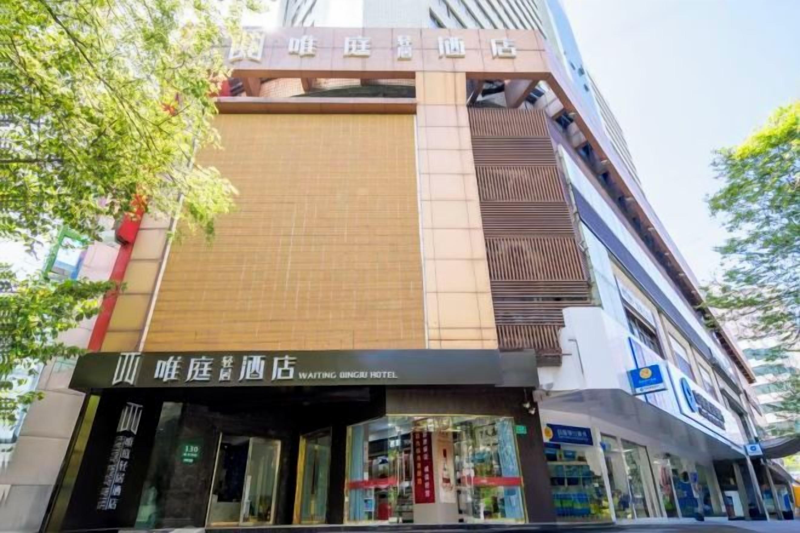 A multi-story hotel with a prominent signage for the 'Whitening Hotel' on the ground floor.