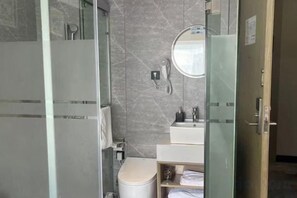 A bathroom with a glass shower enclosure, a toilet, a sink with a mirror, and a towel rack. - Waiting Qingju Hotel (9th People's Hospital Lujiabang Road Subway Station Branch) (Shanghai)