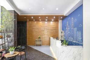 A reception area with a wooden wall, a marble reception desk, and a cityscape mural. - Waiting Qingju Hotel (9th People's Hospital Lujiabang Road Subway Station Branch) (Shanghai)