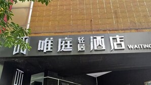 A hotel entrance with a sign in both Chinese and English. - Waiting Qingju Hotel (9th People's Hospital Lujiabang Road Subway Station Branch) (Shanghai)