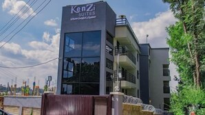 A Kenzi Suites hotel building with a modern design, featuring large windows and a balcony on the upper floor. - Kenzi Suites (Kisii)
